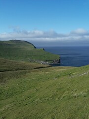 Mountain Hiking in the lush a green hills of the misty Faroe Islands