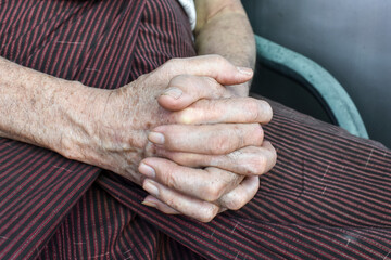 Clasped hands of Asian man. Concept of rheumatoid arthritis, osteoarthritis or joint pain.