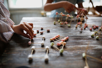 Children play with marshmallows and toothpicks, edible designer in the kitchen. Educational classes and games with children. Child development at home