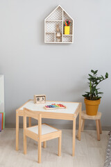 Stylish interior of modern children's room with table and chair