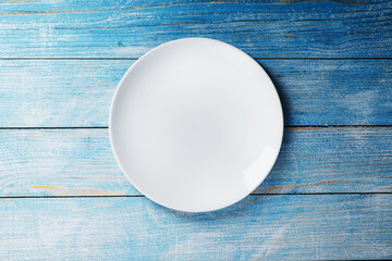 White plate on a blue background top view.