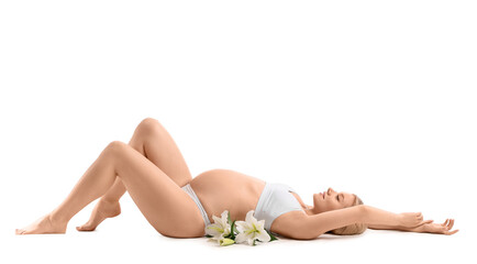 Beautiful pregnant woman with lily flowers lying against white background