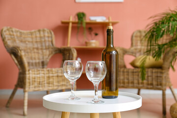 Bottle of wine and glasses on table in living room