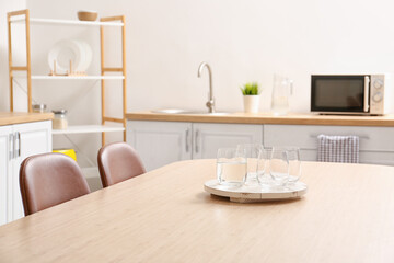 Dining table with glasses of water in modern kitchen