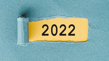 The text 2022 on yellow background under blue paper layer