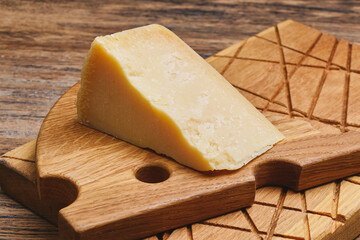 Traditional Italian hard cheese Parmesan or Grana Padano on a wooden kitchen boards.
