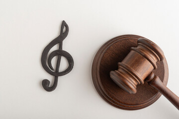 Treble clef symbol and judges hammer. Violation of music copyright. Digital piracy.