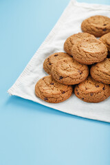Oatmeal cookies on a blue background and a white napkin top view