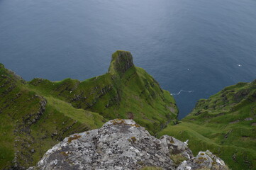 The green and blue dramatic and wild coastal landscapes in the Faroe Islands