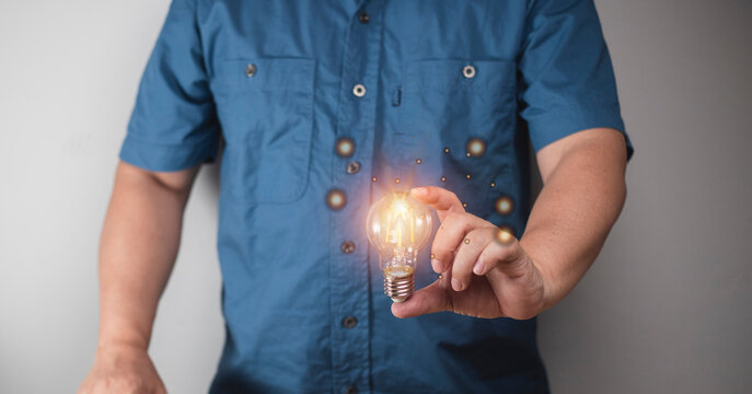 man holding a light bulb Concepts of technology, marketing, communication that can happen all the time.