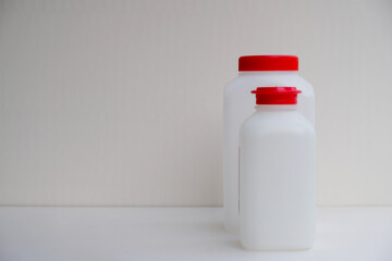 Bright red lids on matte plastic jars. A special set of bottles for the analysis of drinking water in Provence. Ecology concept.  Copy space.