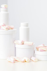 Fototapeta na wymiar Cosmetic skincare packaging. Beauty product on white background. White jars with marshmallows on the white table
