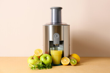 Modern juicer with fresh fruits on table