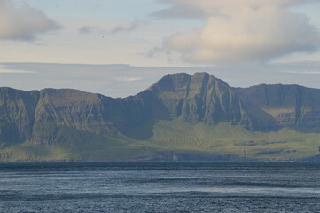 The green and blue dramatic and wild coastal landscapes in the Faroe Islands