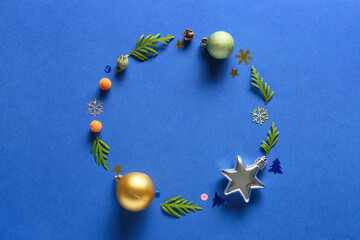 Frame made of fir branches and Christmas decor on blue background