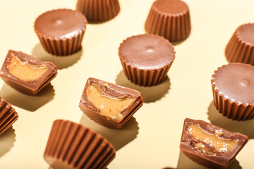 Tasty peanut butter cups on light background