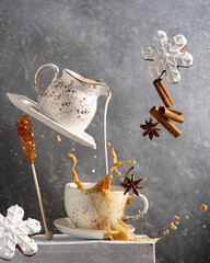 Coffee or tea with milk splash, winter ginger christmas cookies, spices - cinnamon, anise. Levitation art food and drink concept. 