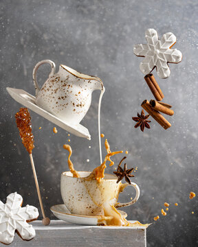 Naklejki Coffee or tea with milk splash, winter ginger christmas cookies, spices - cinnamon, anise. Levitation art food and drink concept. 