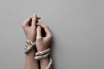 Female hands wrapped with rope. The symbol is not freedom and restrictions in anything
