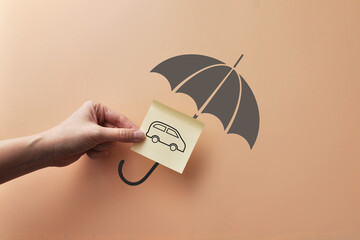 The silhouette of an umbrella and a car under it. Car Insurance Symbol  © fidaolga