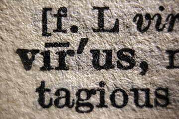 Word "virus" and "violent" printed on dictionary page, macro close-up	