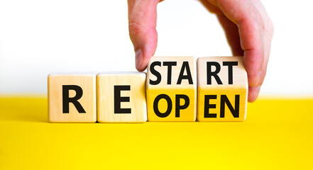 Restart and reopen symbol. Businessman hand turns cubes and changes the word 'recovery' to...