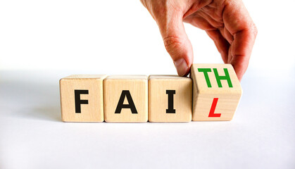 Faith instead fail symbol. Businessman turns a wooden cube and changes the word fail to faith. Beautiful white table, white background. Business and faith instead fail concept. Copy space.