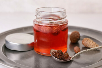 Jar of tasty pine cone jam on table, closeup