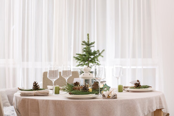 Beautiful table setting with pine cones and fir branches indoors