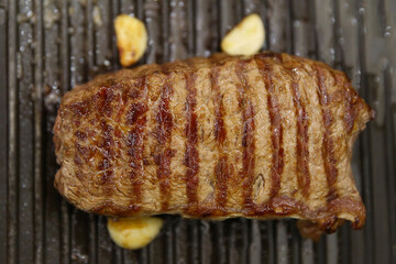 Steak beef meat fried in a grill pan, medium roast meat