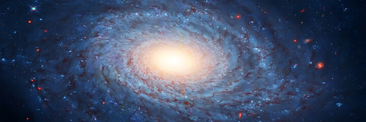 Huge rotating galaxy with a bright warm glow in the center with star systems in the dark sky. Wide...