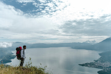 Hombre con mochila roja frente a mirador en un lago de Guatemala, Nariz del Indio