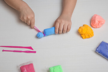 Obraz na płótnie Canvas A child plays with colored plasticine. Development, education.