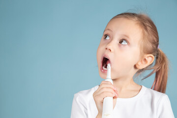 Adorable little caucasian child brushing teeth Standing Over blue Background