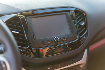 A multimedia panel with a screen and control buttons in a modern car.
