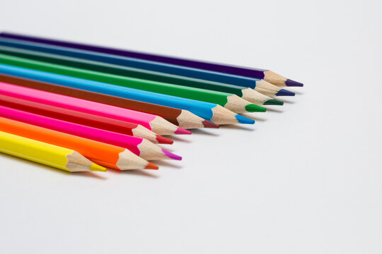 Assortment of coloured pencils on white background. Painting supplies.
