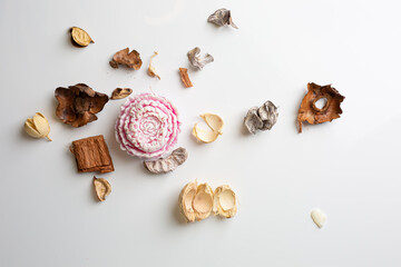 Cozy home interior decor, aromatic candles in glass glowingon white and grey background with natural oil, selective focus of fluffy bunny tail grass, brown jar, lotus flower candle, round matt ceramic