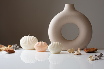 Cozy home interior decor, aromatic burning candles in glass glowingon with natural oil,  fluffy bunny tail grass, brown jar, lotus flower candle, round matt ceramic, seashell candles