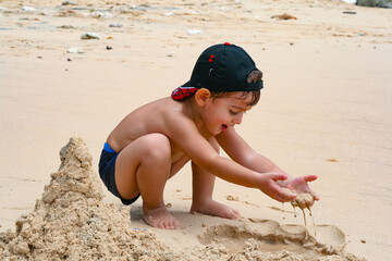 young boy playing in the sand and waves on the beach