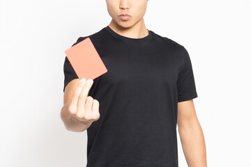 白い背景の前に立ってレッドカードを見せる黒いTシャツを着ている男性