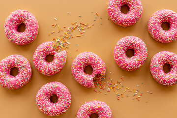 Pink donuts with icing and sprinkles, top view. Sweet snacks set