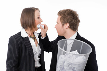 Geschäftsmann stopft Geschäftsfrau einen Papierknäuel in den Mund