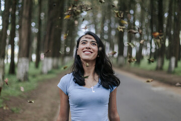 Mujer joven con pelo largo sonriendo en bosque