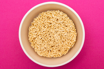 Opened Package with Uncooked Instant Noodles on Pink Background. Raw Pasta. Dry Asian Fast Food. Quick Lunch