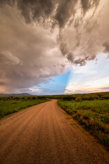 Dirt road in Arizona countryside with ominous dark monsoon clouds