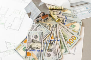 Money against the background of the house layout. Salary for builders. Vacancies for builders. Training in construction professions.