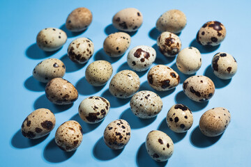 Top view - Quail eggs on pastel blue background. Minimal Happy Easter composition. Minimalism or healthy lifestyle diet concept.