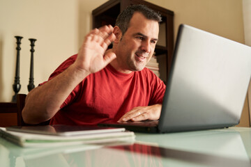 a man talking on a video call with his laptop
