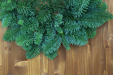 Christmas and New Year background. Green spruce branches on a wooden background. View from above. Copy space