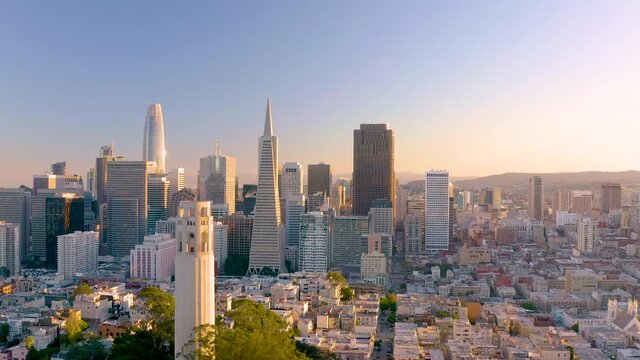 4K aerial daytime video footage of San Francisco, California, at sunset, as seen coming from the bay towards Coit Tower which is passed on left of frame.